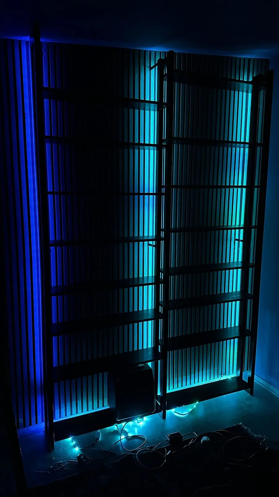 Slatted wall lit turquoise from behind