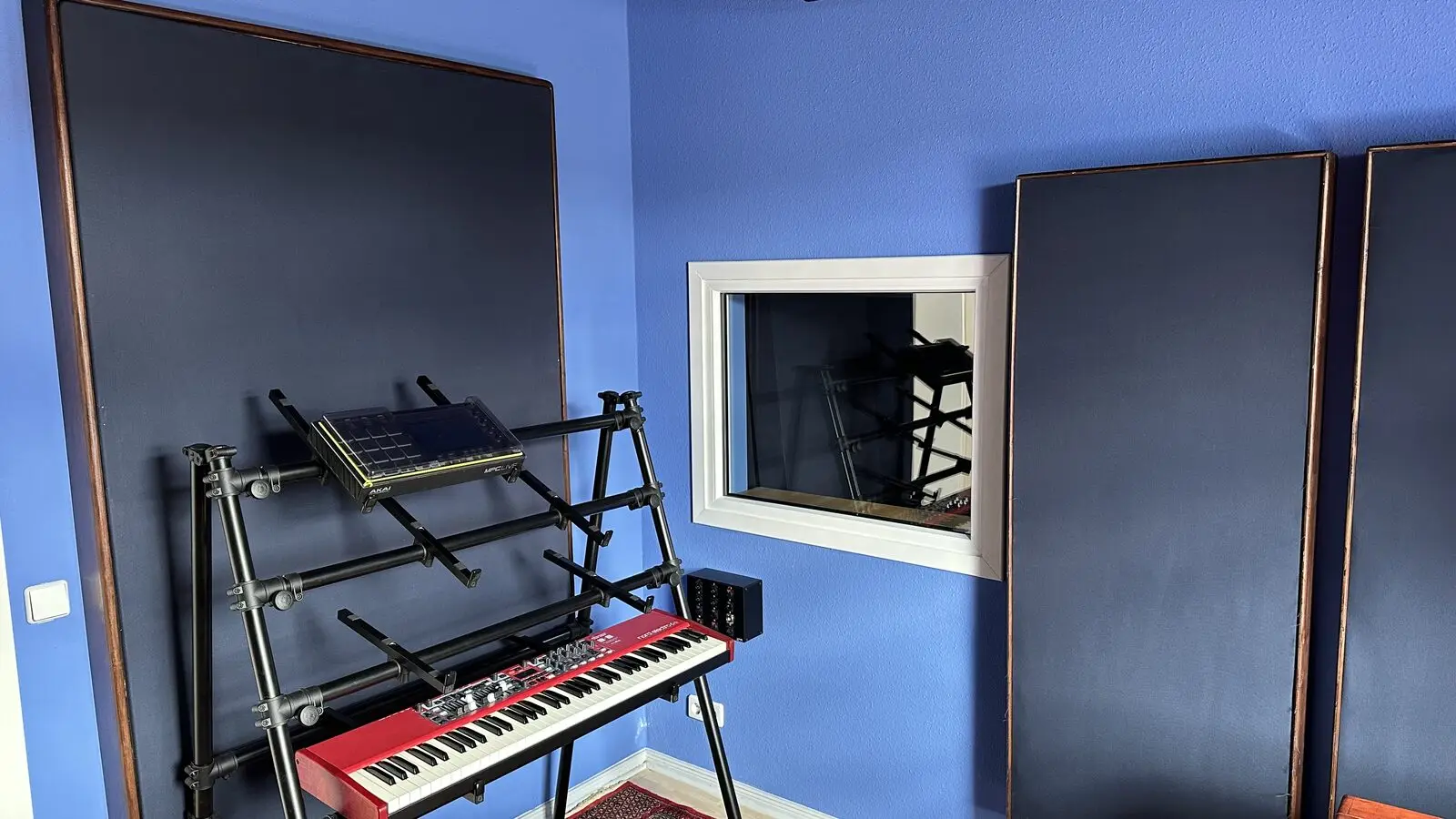 Room with black absorbers, a red keyboard and the window to the booth