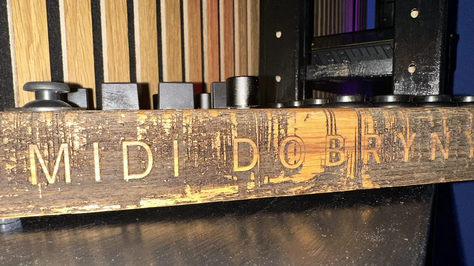MIDI DOBRYN milled into wood, black knobs above it