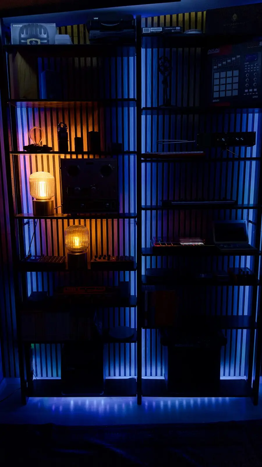 The lit slatted wall with shelves, seen from below