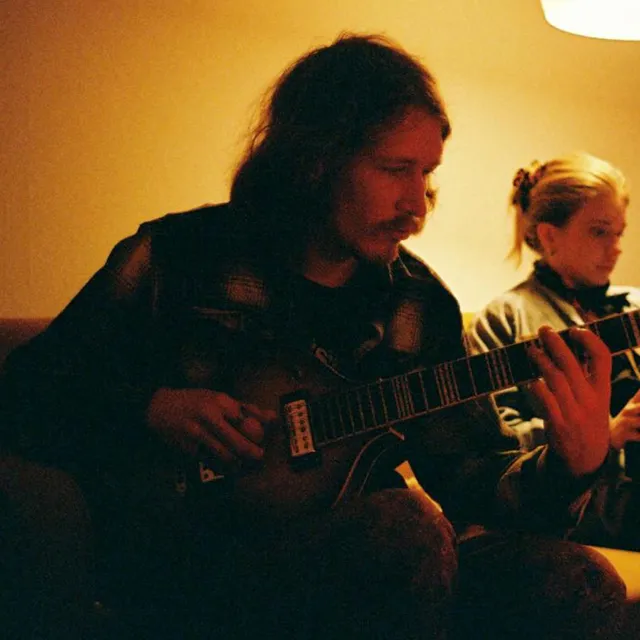 Grischa with an electric guitar in warm light