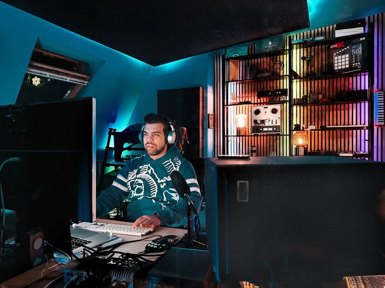 At the desk between the monitors, mixing